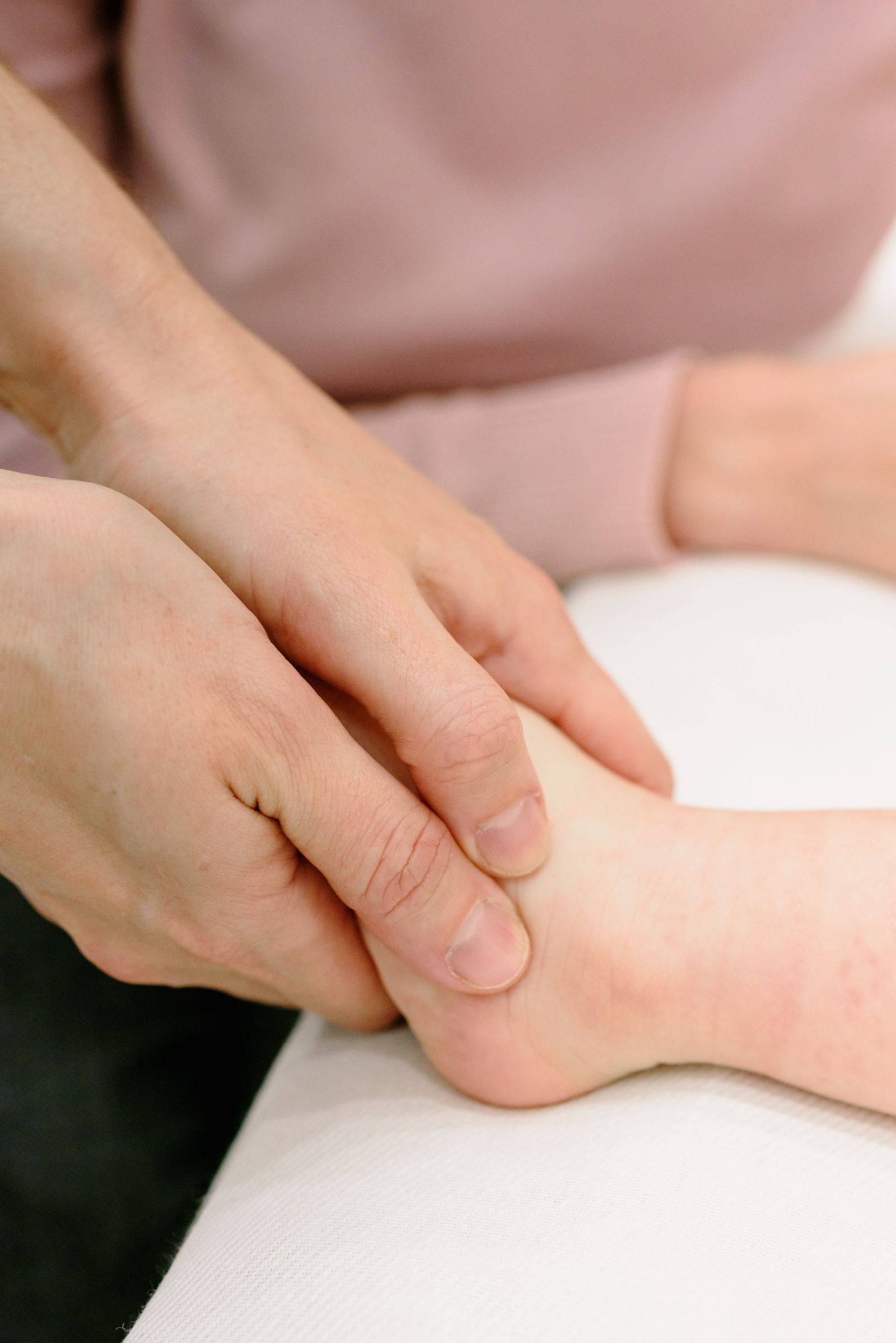 Close-up of hands gently massaging a foot, illustrating technique