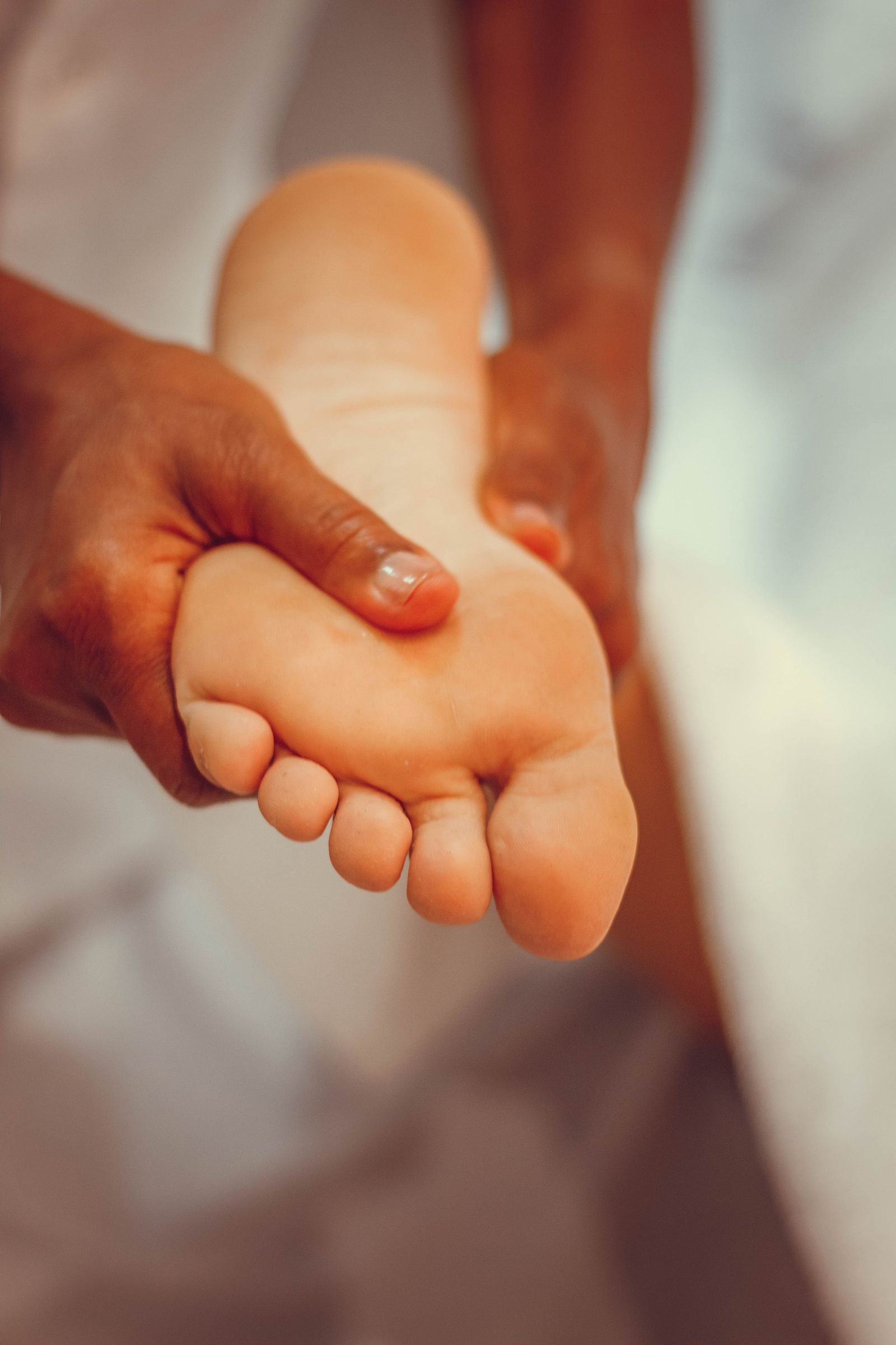 Close-up of hands supporting and massaging a foot, illustrating technique